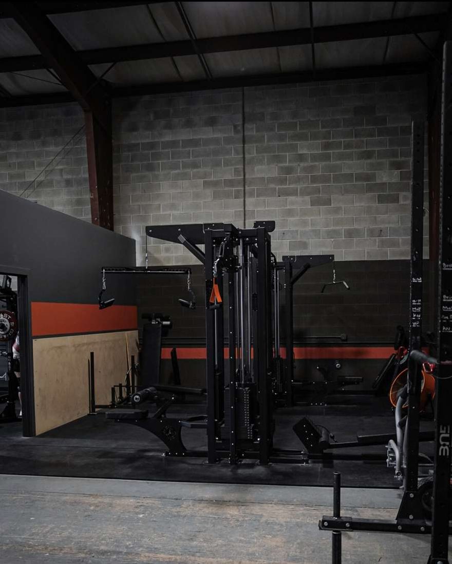 The Arsenal Strength eight-station cable system standing against the block wall at The Forge Gym.