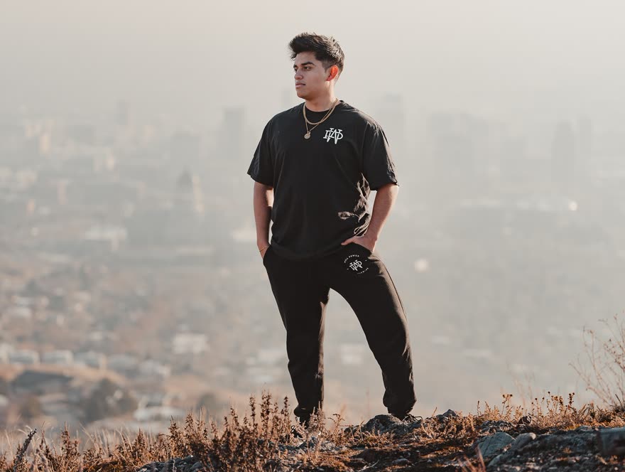 Willy, the owner of The Forge Gym, standing on a hillside above the Salt Lake valley in Will Power Fitness gear.